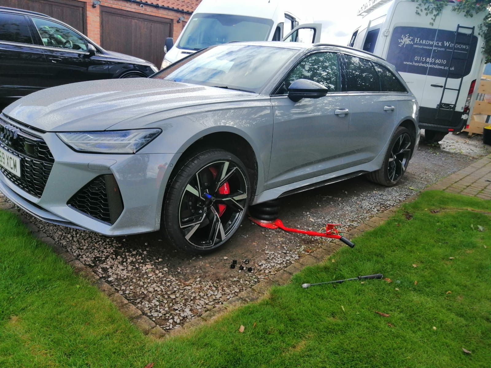 Silver Audi RS6 Avant jacked up on a gravel driveway