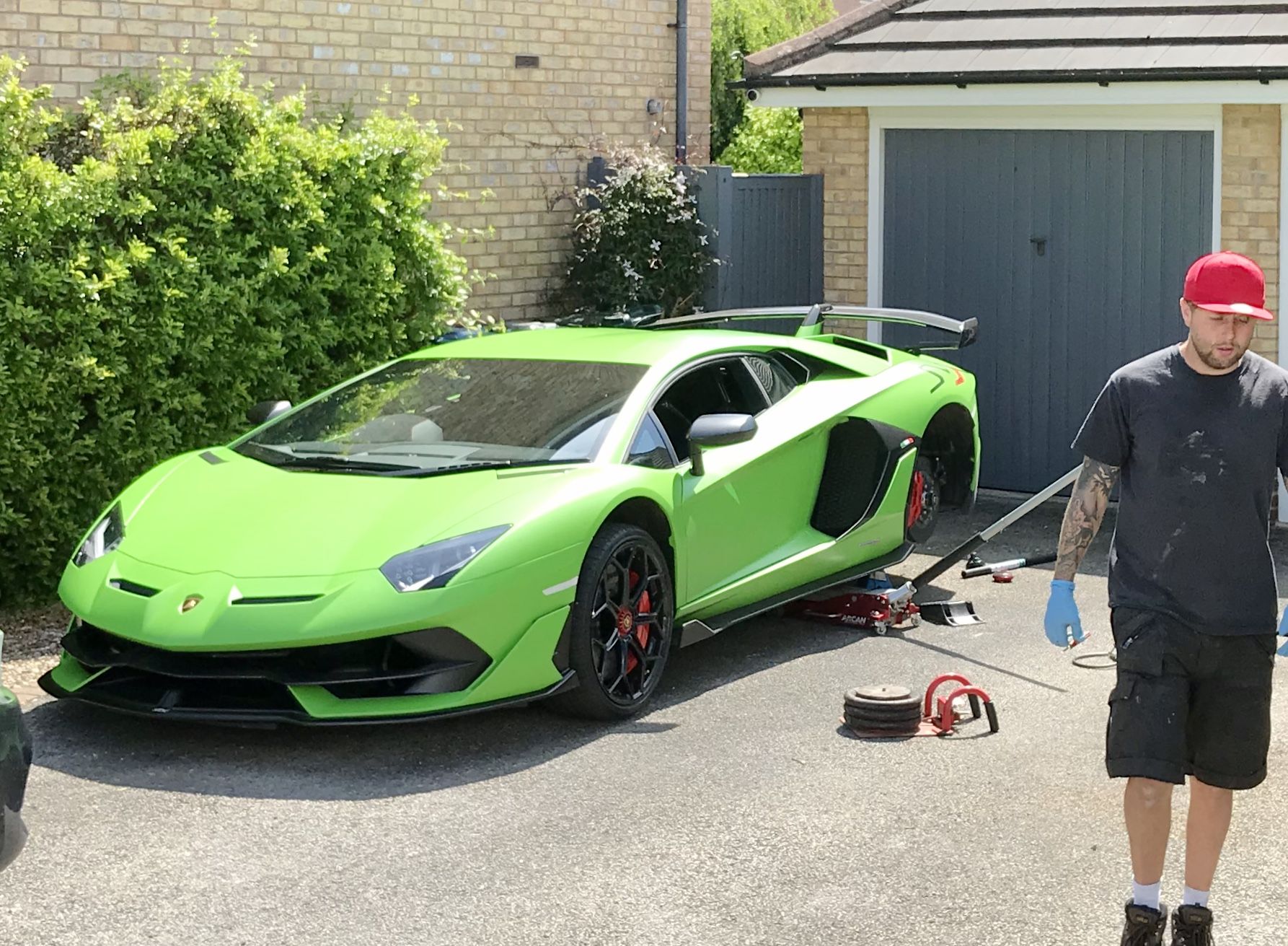 Green Lamborghini Aventador on a driveway with our fitter alongside